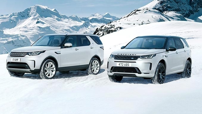 Two white Discovery cars in the snow