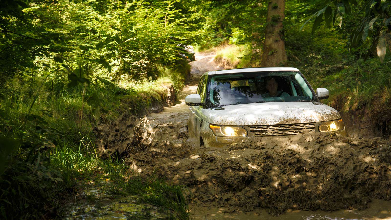 A Land Rover vehicle driving through muddy water